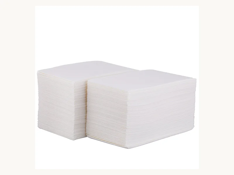 Two stacks of interfolded white disposable face towels